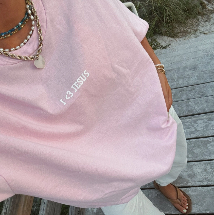 minimalistic Jesus tshirt "I <3 Jesus" in a short sleeve light pink tshirt with white pants and sandals