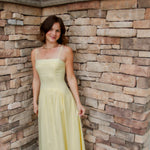 yellow midi dress with drop waist, textured detail, adjustable spaghetti straps and white sandals