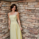 yellow midi dress with drop waist, textured detail, adjustable spaghetti straps and white sandals