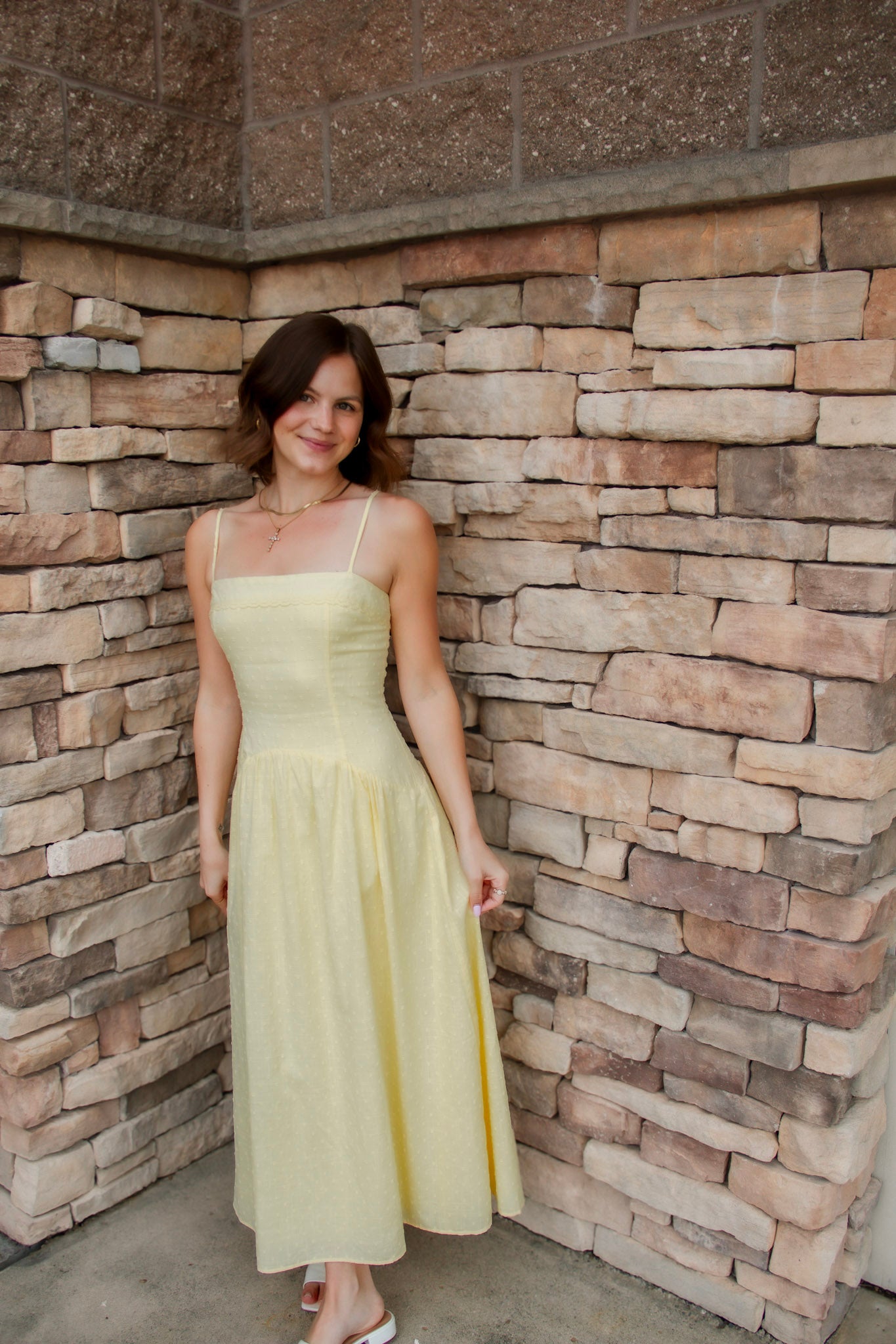 yellow midi dress with drop waist, textured detail, adjustable spaghetti straps and white sandals