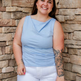 Stunning light baby blue colored tank with a cowl neckline. Paired with white denim pants.