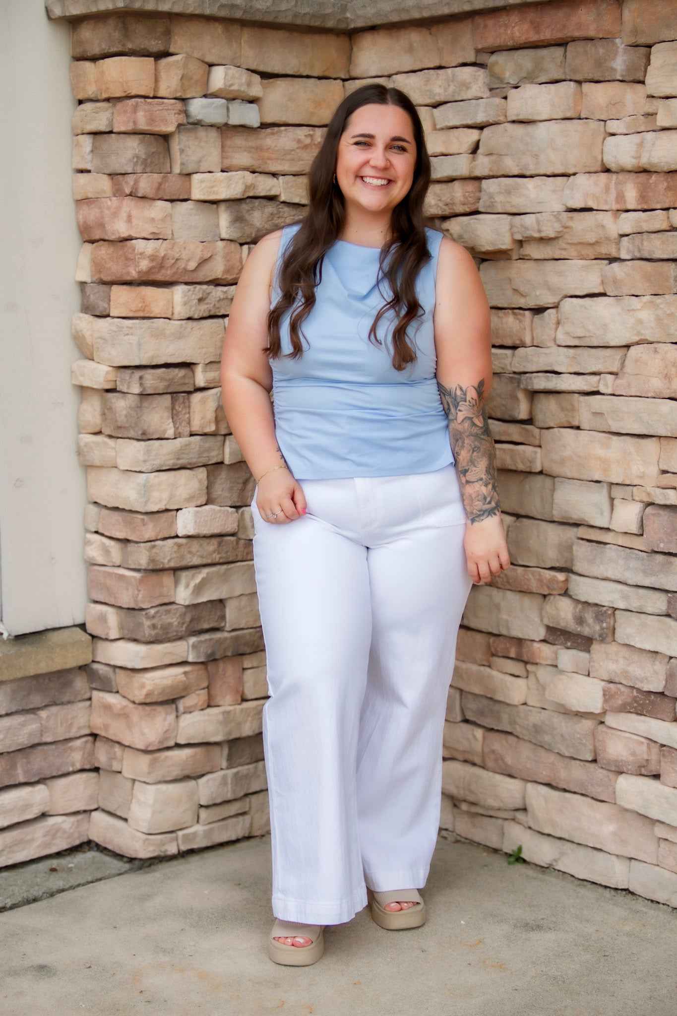 Stunning light baby blue colored tank with a cowl neckline. Paired with white denim pants.