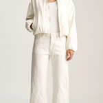 Person wearing a white outfit on a plain background