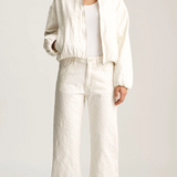 Person wearing a white outfit on a plain background