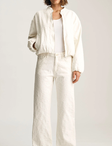 Person wearing a white outfit on a plain background