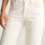 White textured pants worn by a person on a light gray background