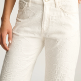 White textured pants worn by a person on a light gray background