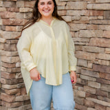 yellow textured button down that is semi-sheer paired back to denim 