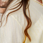 yellow textured button down that is semi-sheer paired back to denim 