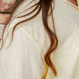 yellow textured button down that is semi-sheer paired back to denim 