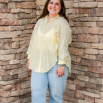 yellow textured button down that is semi-sheer paired back to denim 