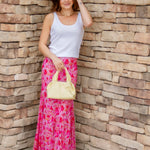 pink maxi skirt and white tank with yellow handbag