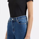 Person wearing a black t-shirt and blue jeans on a white background