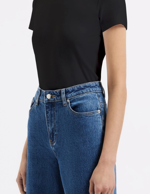 Person wearing a black t-shirt and blue jeans on a white background