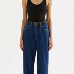 woman wearing a black scoop neck tank top with dark wash jeans