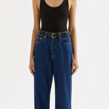 woman wearing a black scoop neck tank top with dark wash jeans