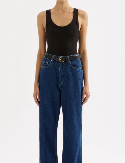woman wearing a black scoop neck tank top with dark wash jeans