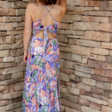 Floral midi dress with purple, green, coral and white colors. Pleated skirt and adjustable straps. backside of dress with tie-back detail and a slight open-back
