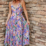 Floral midi dress with purple, green, coral and white colors. Pleated skirt and adjustable straps. 