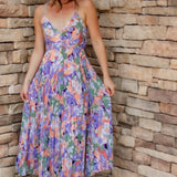 Floral midi dress with purple, green, coral and white colors. Pleated skirt and adjustable straps. 