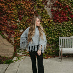 grey poncho sweater with fringe detail on the ends and turtleneck
