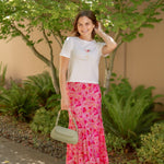 white tee with spicy marg embroidered with pink floral skirt and green bag