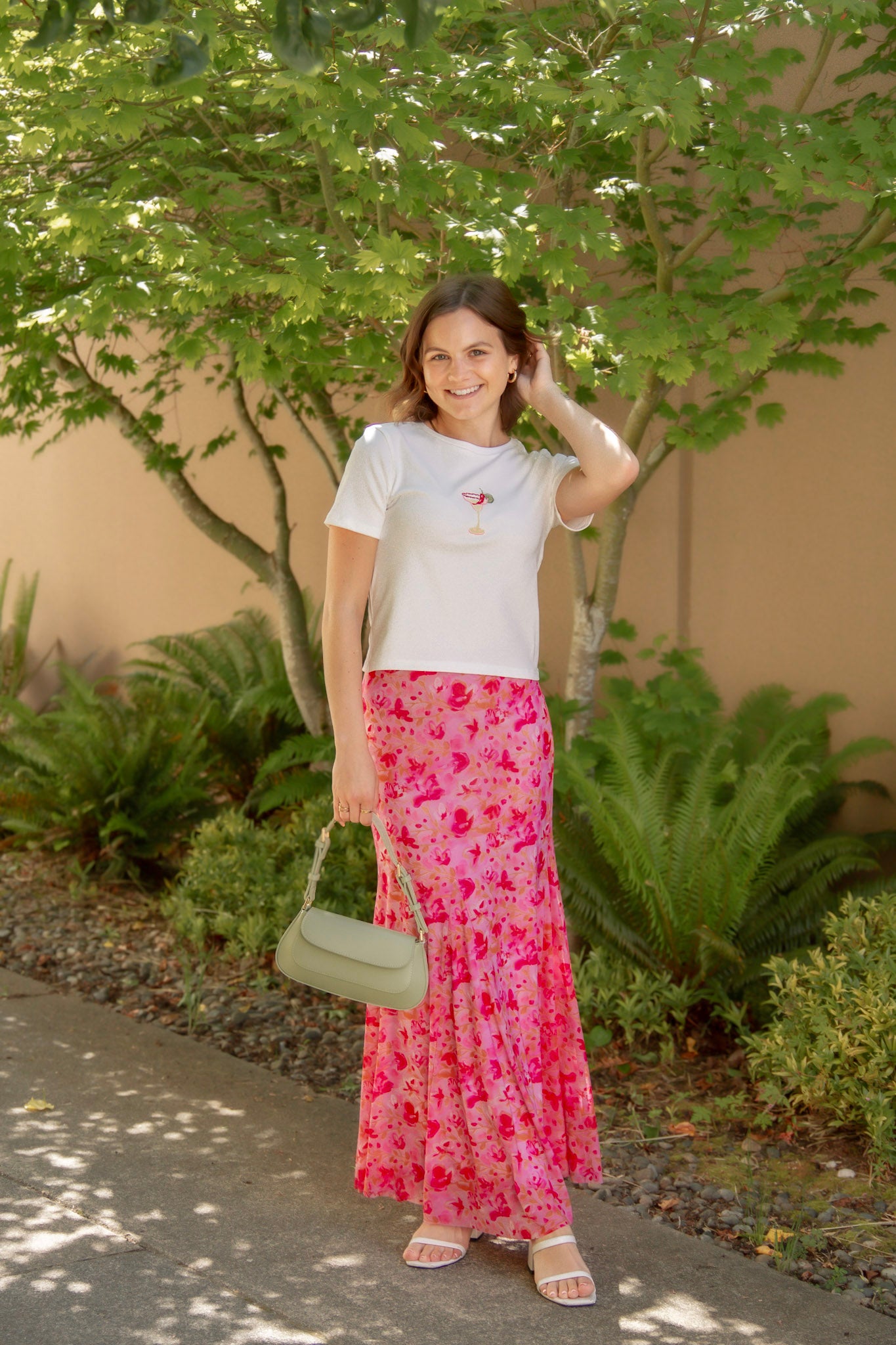 white tee with spicy marg embroidered with pink floral skirt and green bag