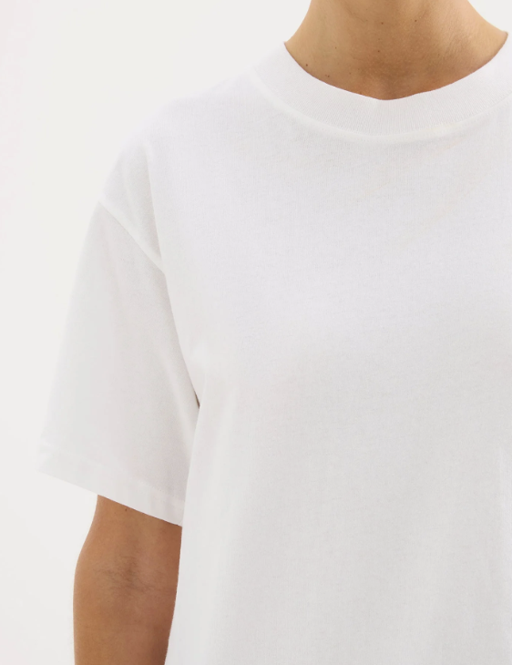 A girl in a white boxy oversized boyfriend style tshirt 