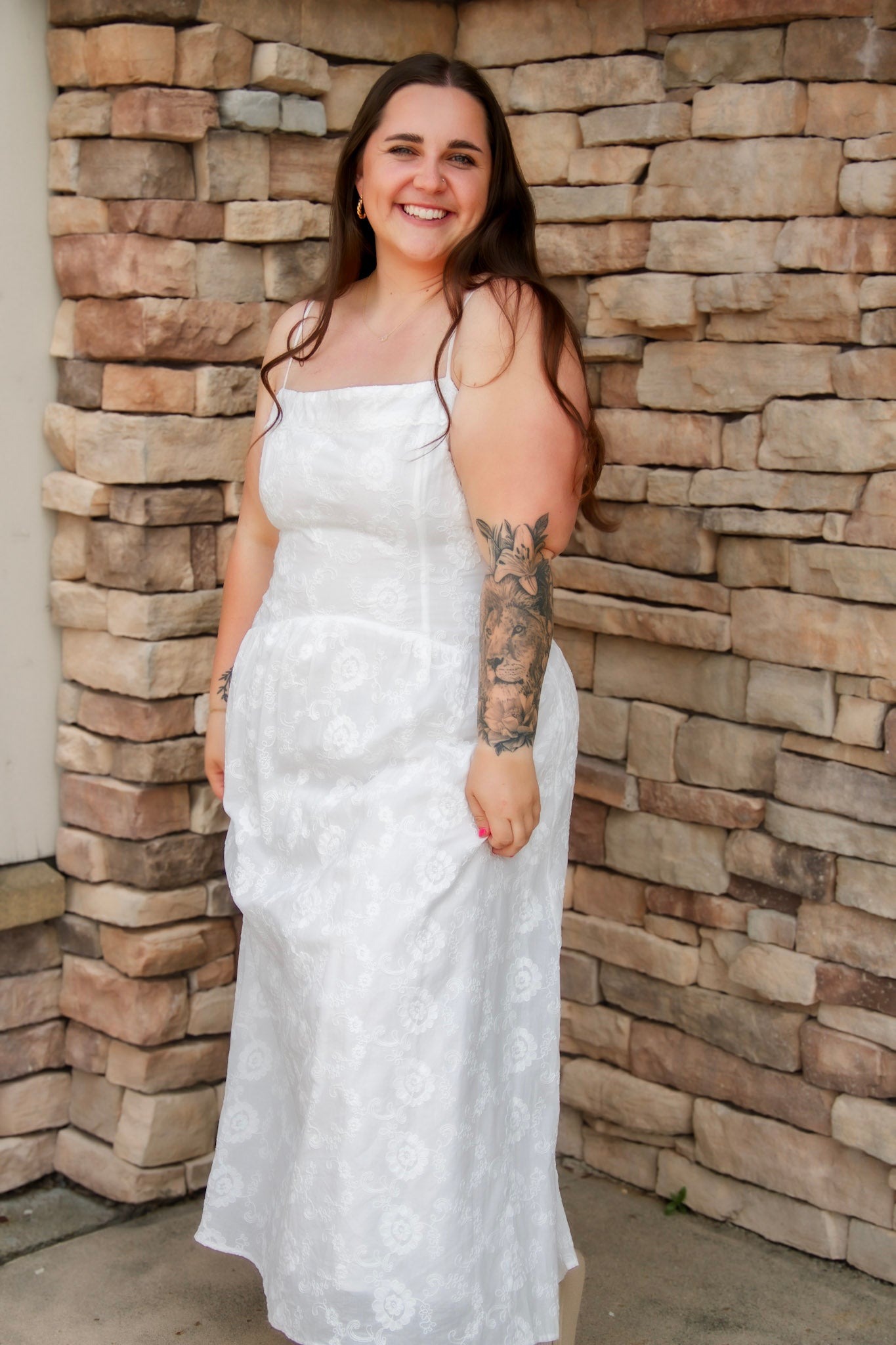 woman wearing a white spaghetti strap midi dress with embroidered details