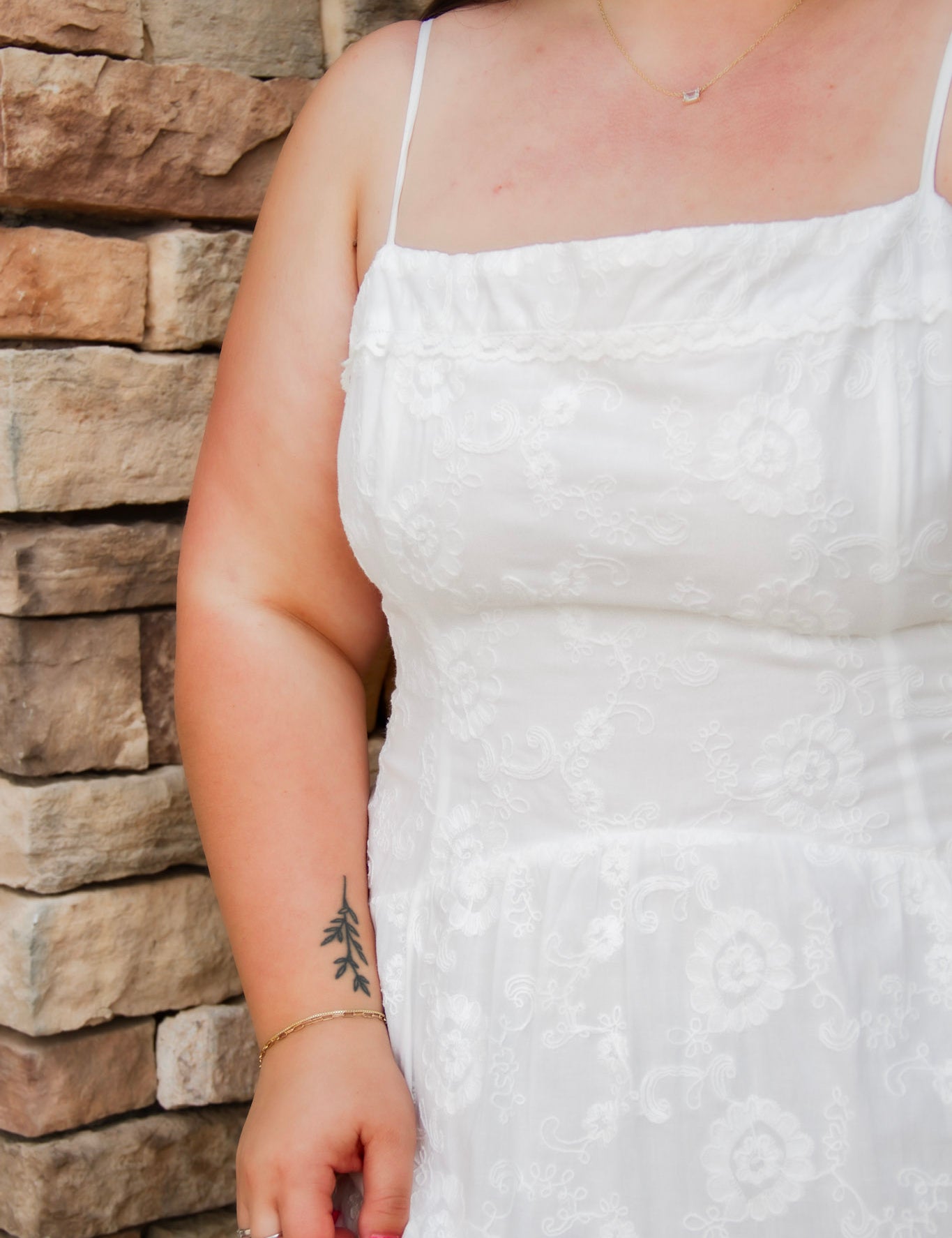 woman wearing a white spaghetti strap midi dress with embroidered details