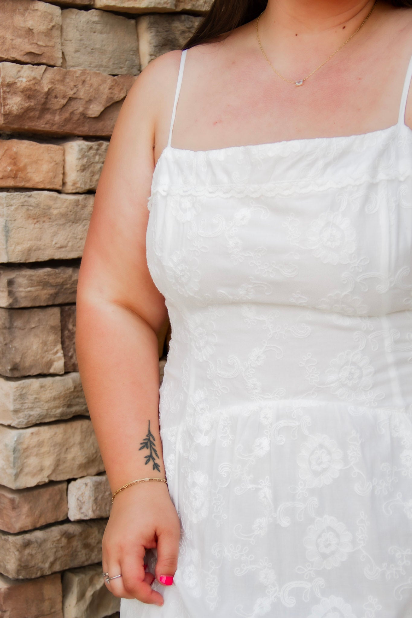 woman wearing a white spaghetti strap midi dress with embroidered details