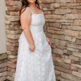woman wearing a white spaghetti strap midi dress with embroidered details