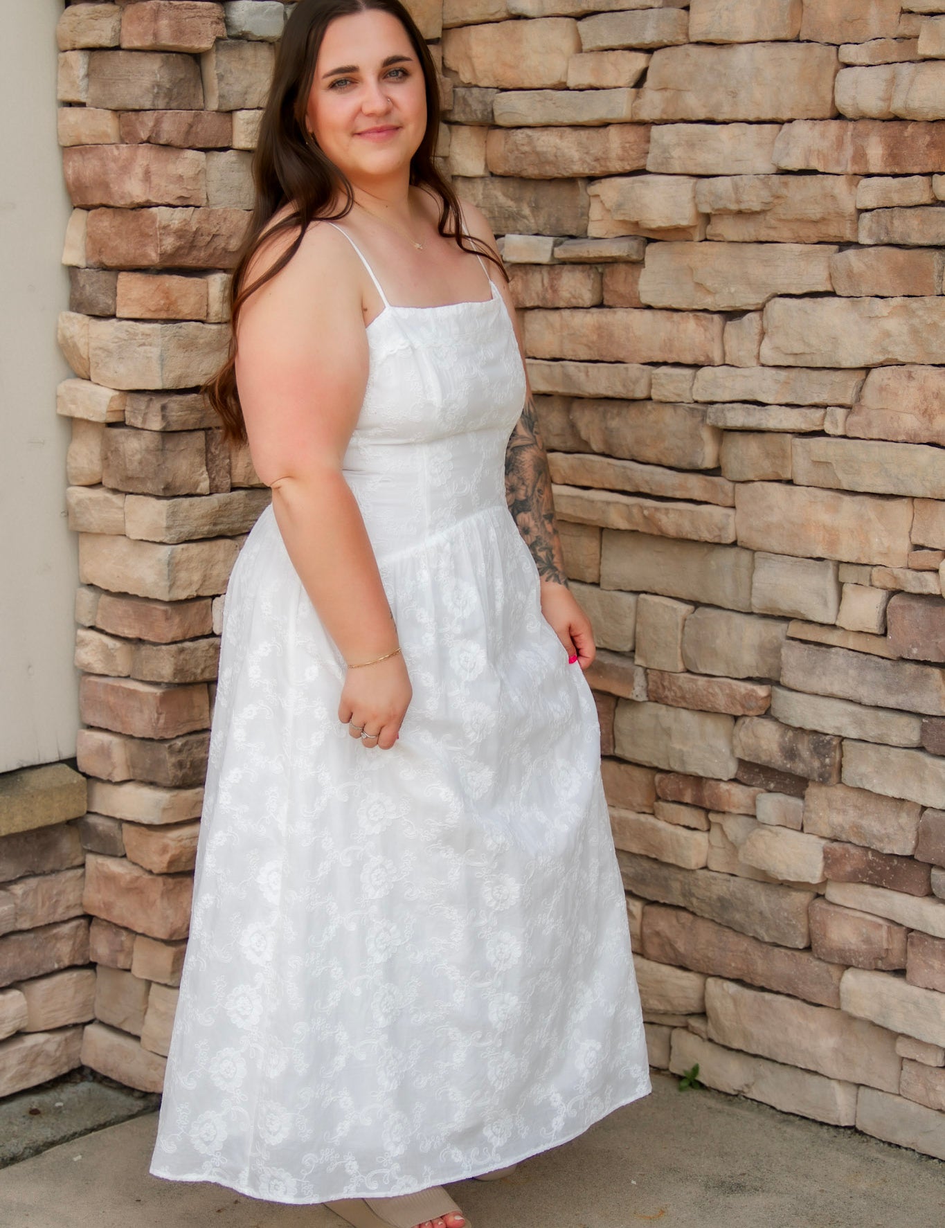 woman wearing a white spaghetti strap midi dress with embroidered details