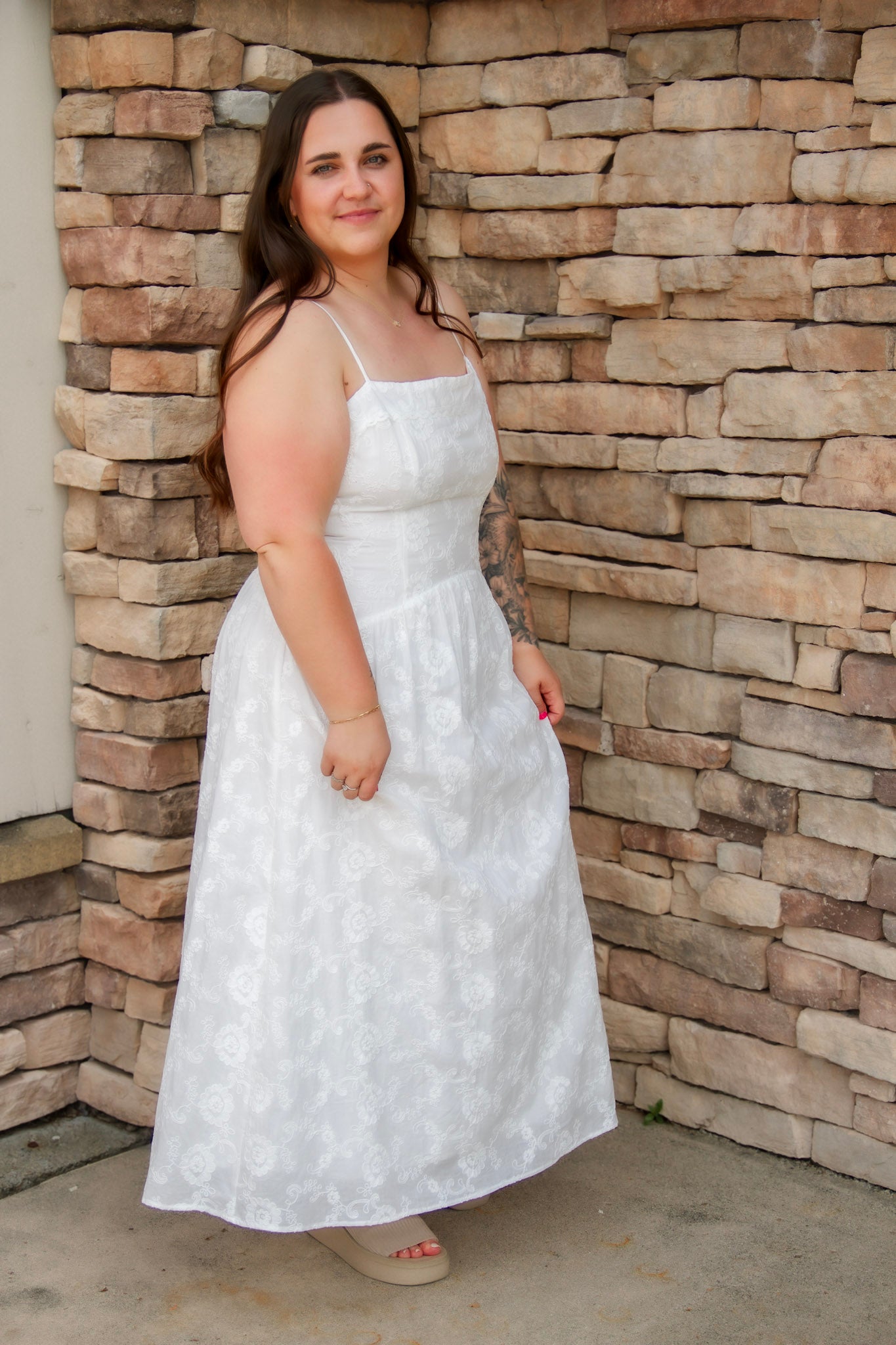 woman wearing a white spaghetti strap midi dress with embroidered details