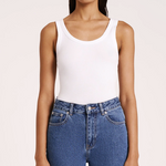 woman wearing white scoop neck ribbed tank top with medium wash jeans