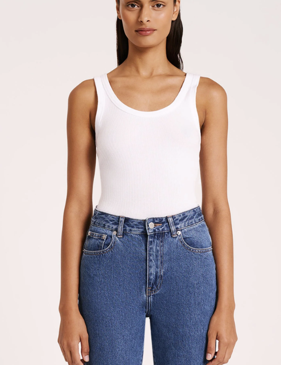 woman wearing white scoop neck ribbed tank top with medium wash jeans