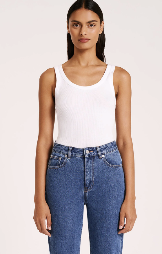 woman wearing white scoop neck ribbed tank top with medium wash jeans
