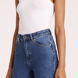 white ribbed tank top with thick straps and medium wash jeans 