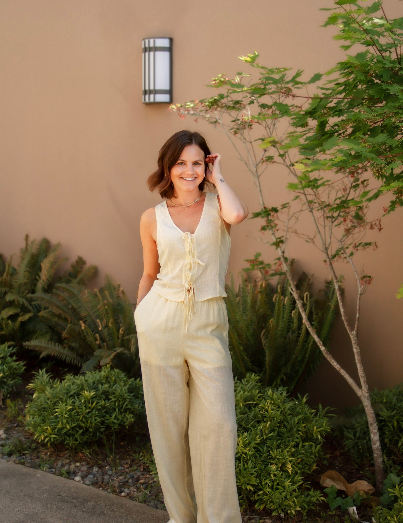 yellow linen tie front tank top and yellow linen drawstring pants paired with white sandals and gold jewelry