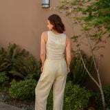 yellow linen tie front tank top and yellow linen drawstring pants paired with white sandals and gold jewelry