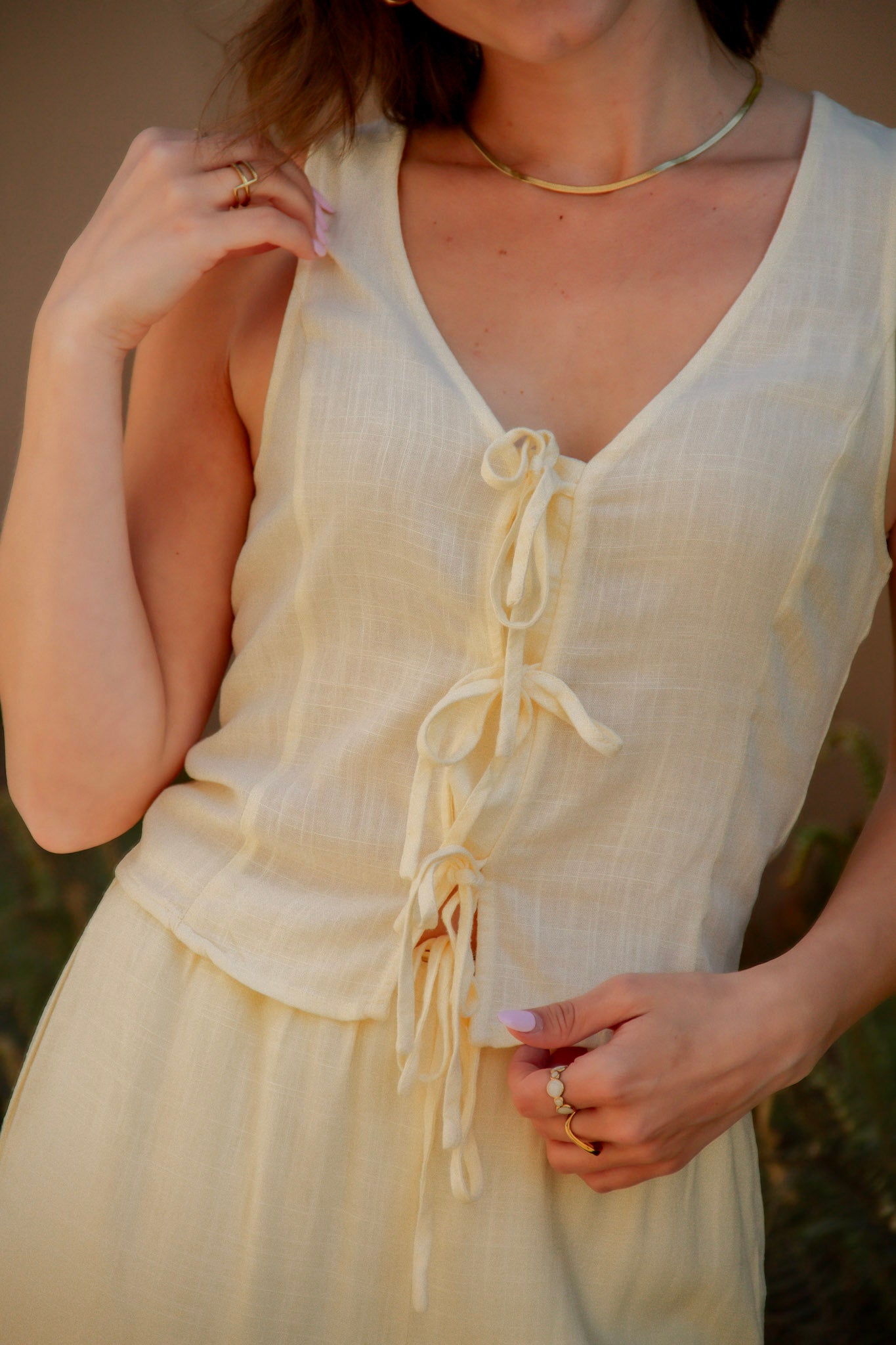 yellow sleeveless tank top with ties on the front and a matching yellow drawstring linen pant