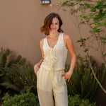 yellow sleeveless tank top with ties on the front and a matching yellow linen pant