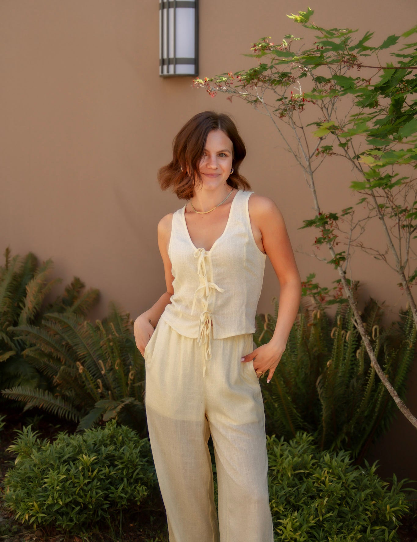 yellow sleeveless tank top with ties on the front and a matching yellow linen pant