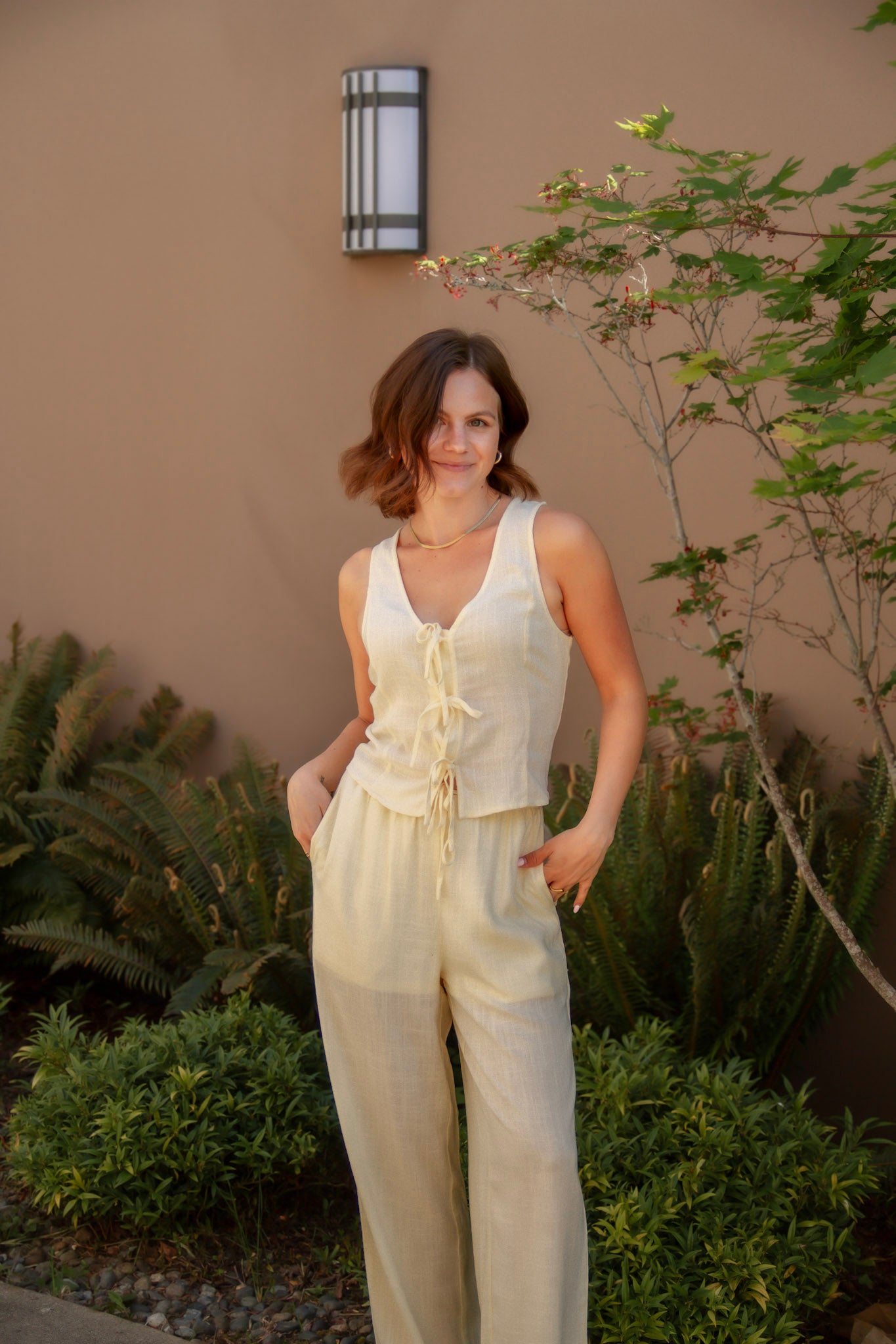 yellow sleeveless tank top with ties on the front and a matching yellow linen pant