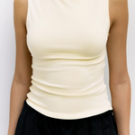 Yellow sleeveless top worn by a person on a plain background
