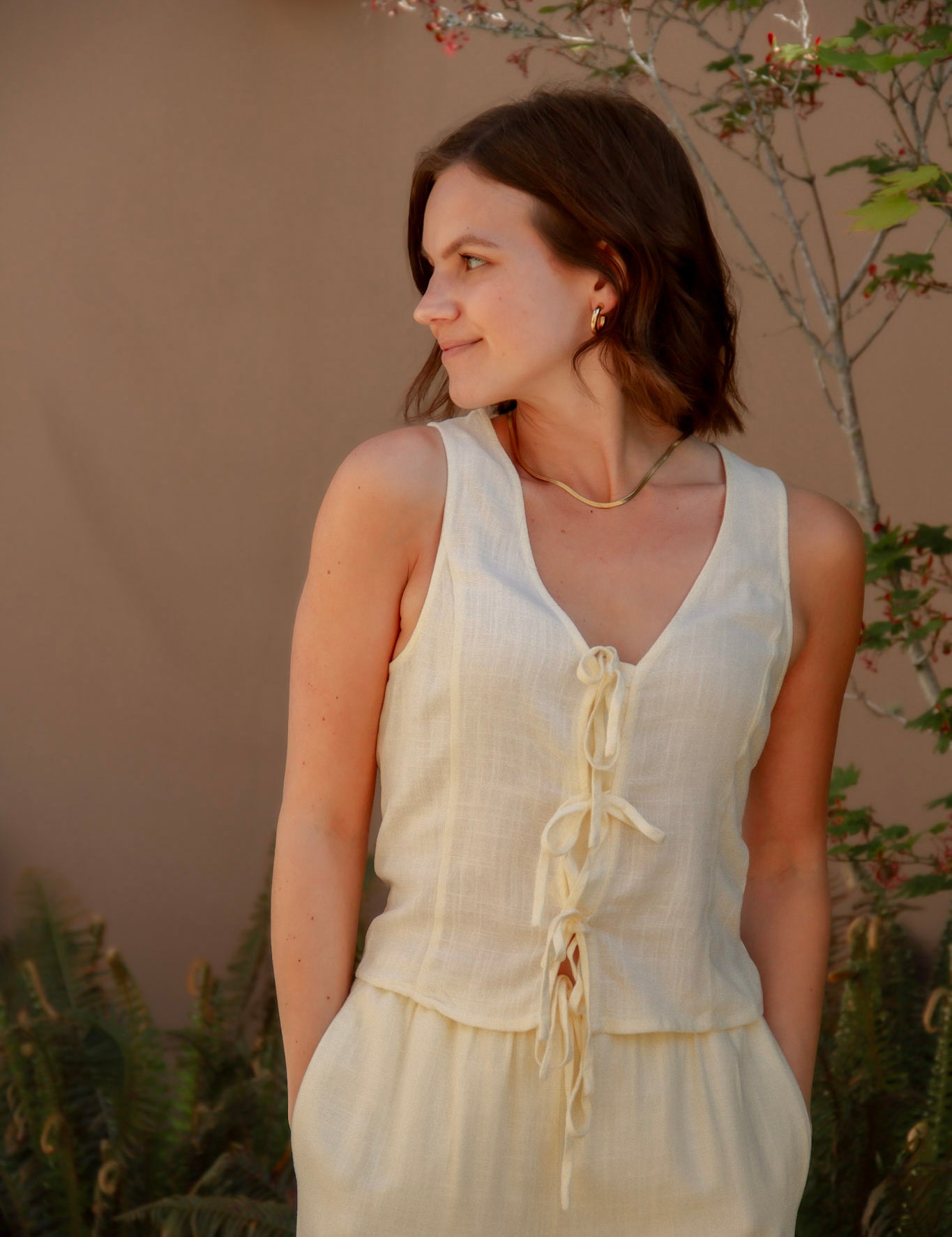 yellow sleeveless tank top with ties on the front and a matching yellow linen pant