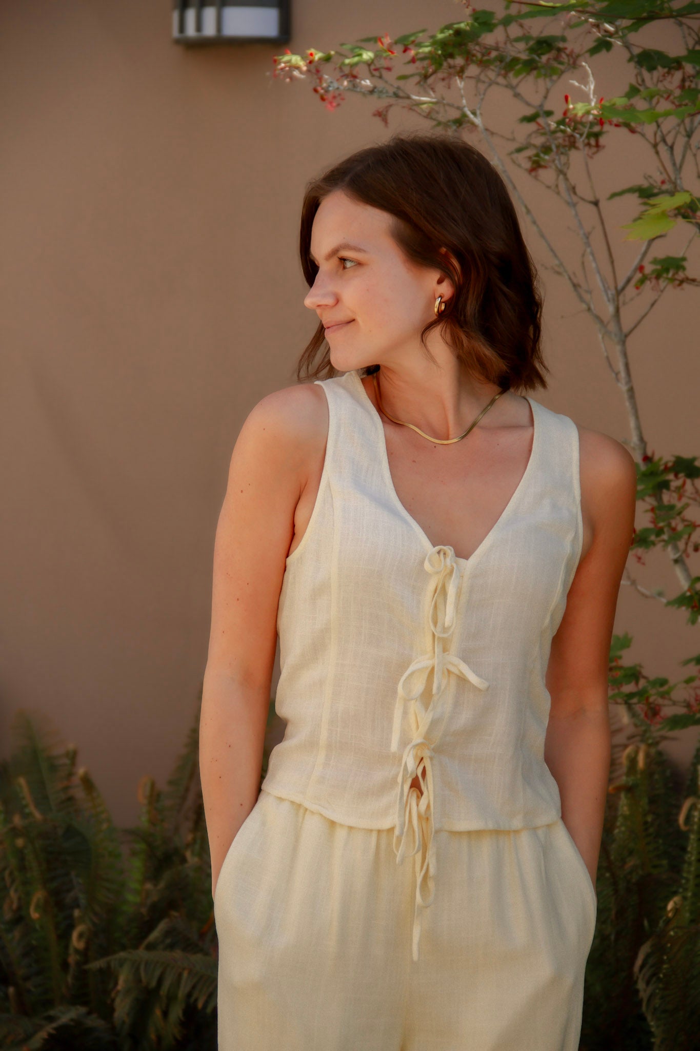 yellow sleeveless tank top with ties on the front and a matching yellow linen pant